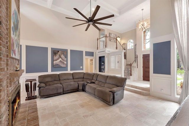 living room with a decorative wall, a high ceiling, a wealth of natural light, and coffered ceiling