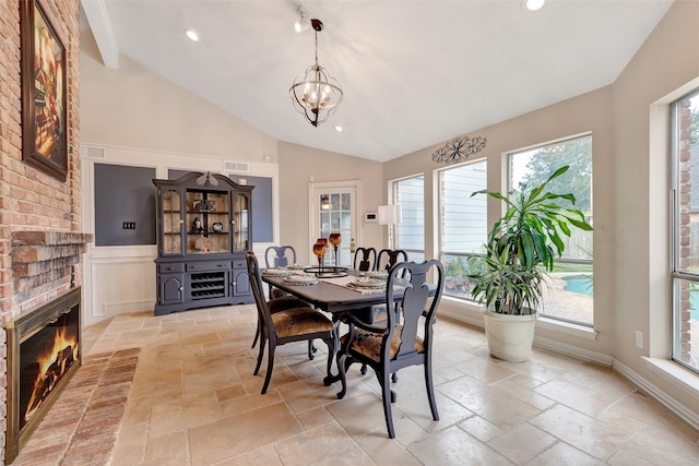 dining room featuring lofted ceiling, stone tile floors, a chandelier, and recessed lighting