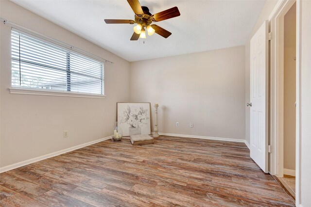 unfurnished bedroom with baseboards, a ceiling fan, and wood finished floors