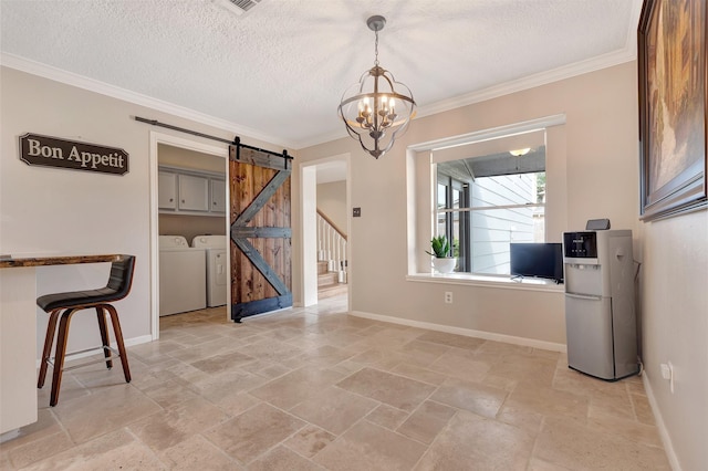 unfurnished dining area featuring baseboards, stone tile flooring, washer and dryer, and a barn door
