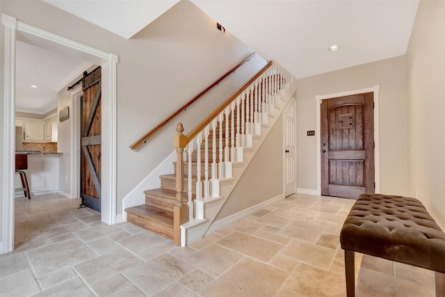 stairway with a barn door, stone tile flooring, baseboards, and recessed lighting