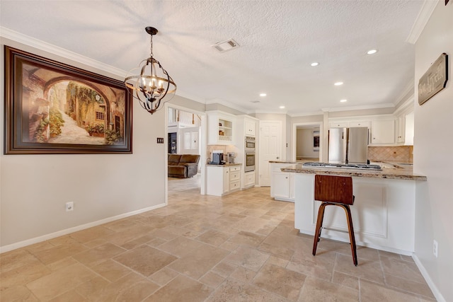 kitchen with stone tile flooring, freestanding refrigerator, recessed lighting, a chandelier, and decorative backsplash