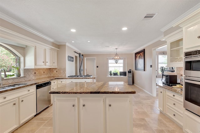 kitchen featuring recessed lighting, stainless steel appliances, visible vents, a sink, and a kitchen island