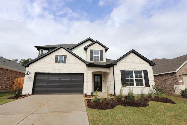 traditional home featuring a garage, brick siding, and concrete driveway