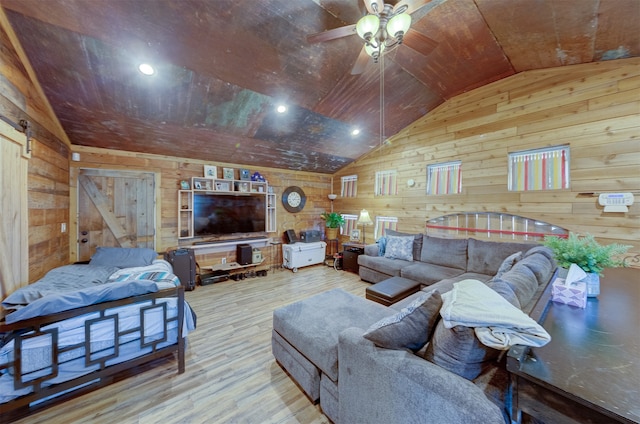 living room with wood walls, hardwood / wood-style floors, ceiling fan, and vaulted ceiling