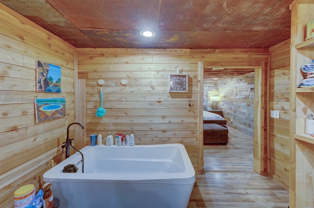 bathroom with a bathtub, wood walls, hardwood / wood-style floors, and wooden ceiling