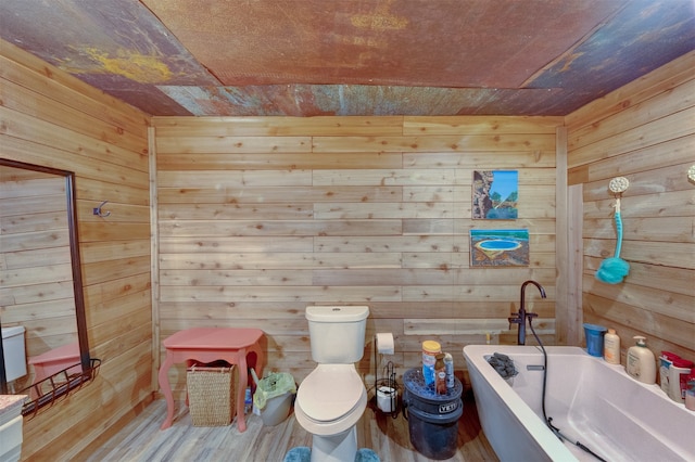 bathroom with a tub to relax in, wood walls, hardwood / wood-style flooring, and toilet