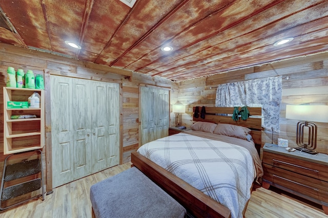 bedroom featuring light wood-type flooring and wooden walls