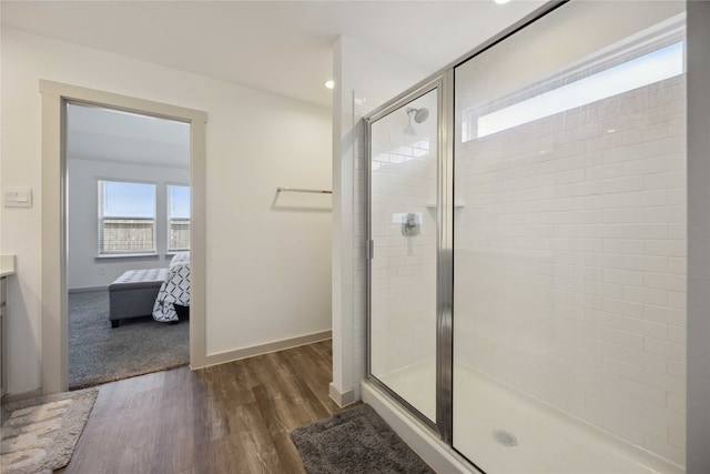 bathroom featuring walk in shower, vanity, and hardwood / wood-style floors