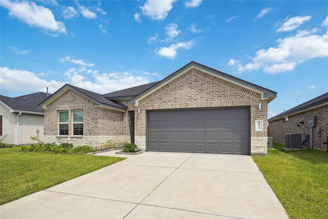 view of front of property featuring a garage, central air condition unit, and a front yard