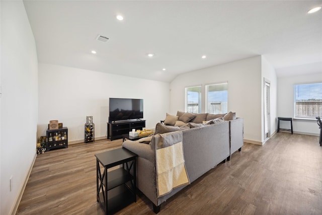 living room with lofted ceiling, plenty of natural light, and dark hardwood / wood-style flooring