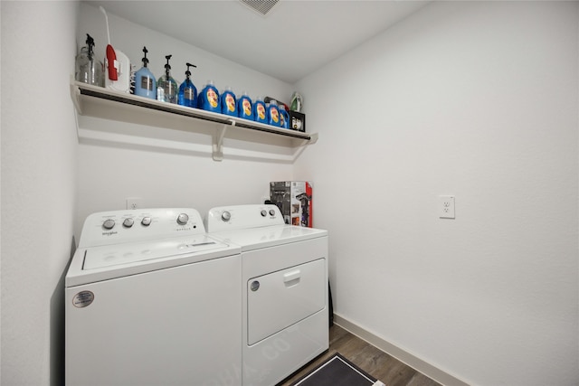 laundry area with separate washer and dryer and dark wood-type flooring