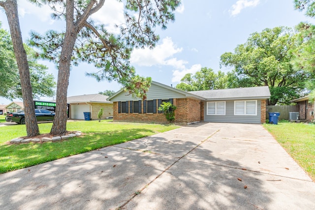 ranch-style home with central air condition unit and a front yard