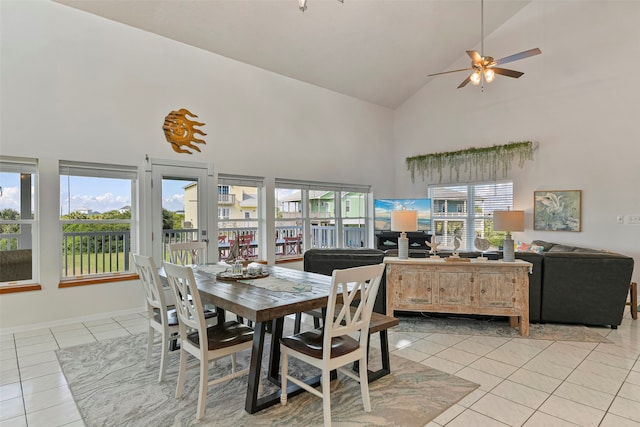 tiled dining space featuring ceiling fan and high vaulted ceiling