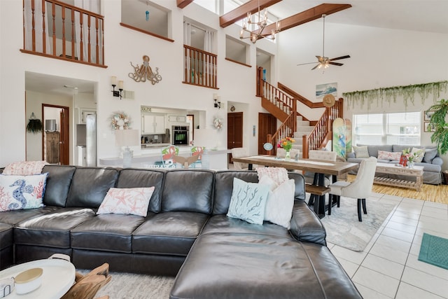 tiled living room with ceiling fan with notable chandelier and vaulted ceiling