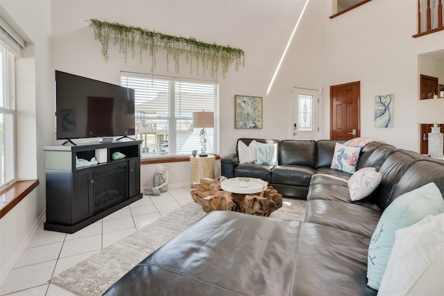 living room with light tile patterned floors and a towering ceiling