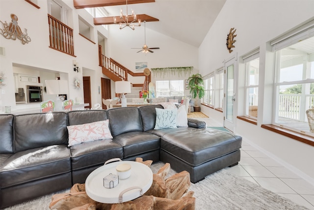 living room with light tile patterned floors, ceiling fan with notable chandelier, a wealth of natural light, and high vaulted ceiling