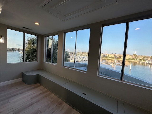 unfurnished sunroom featuring a water view