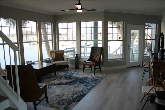 interior space with light hardwood / wood-style flooring, ceiling fan, and ornamental molding