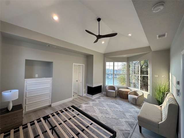 living room with light hardwood / wood-style floors, lofted ceiling, and ceiling fan