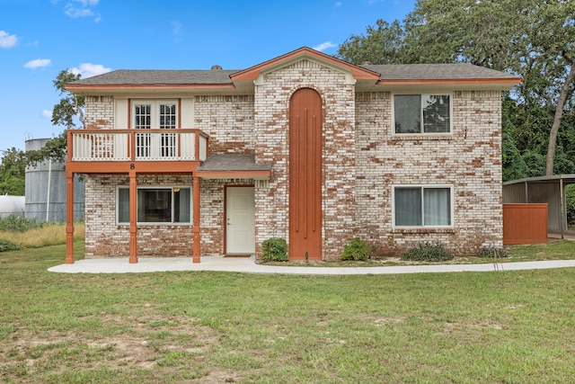 view of front of house with a balcony and a front lawn