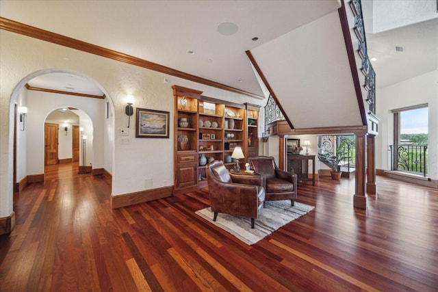 living room with visible vents, crown molding, arched walkways, wood finished floors, and baseboards