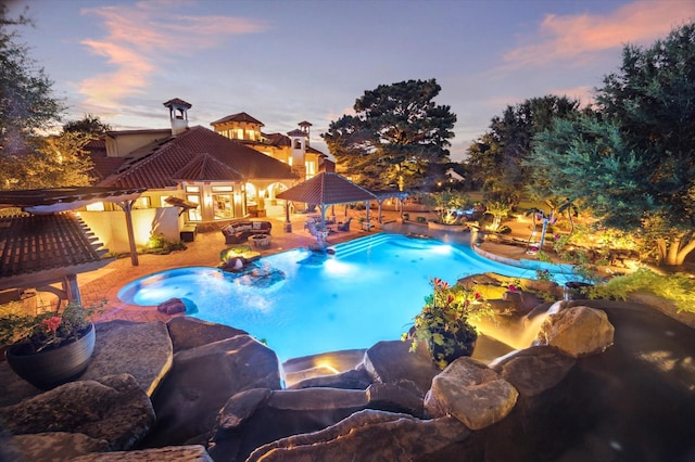 pool at dusk featuring a gazebo, a fenced backyard, an outdoor pool, and a patio