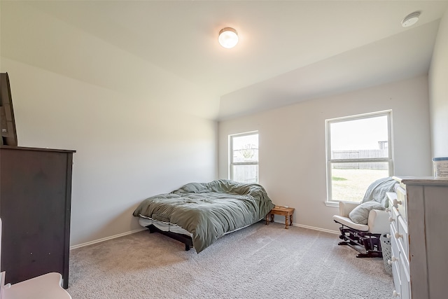 carpeted bedroom with lofted ceiling and multiple windows