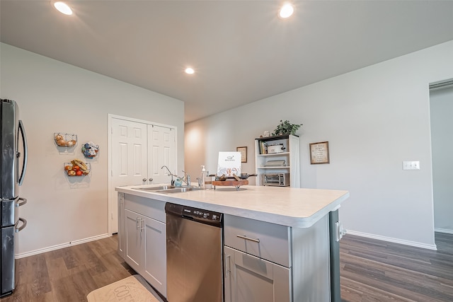 kitchen with a kitchen island with sink, sink, gray cabinetry, appliances with stainless steel finishes, and dark hardwood / wood-style flooring