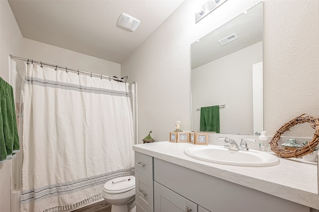 full bathroom with shower / tub combo with curtain, vanity, and toilet