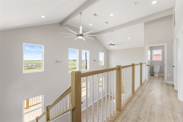 hallway with light hardwood / wood-style flooring, beam ceiling, and high vaulted ceiling