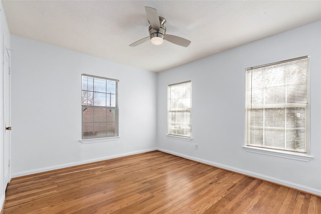 spare room featuring ceiling fan, a textured ceiling, hardwood / wood-style floors, and a healthy amount of sunlight