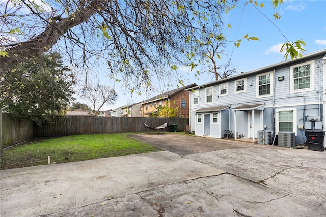 back of house with a patio, a yard, and central air condition unit