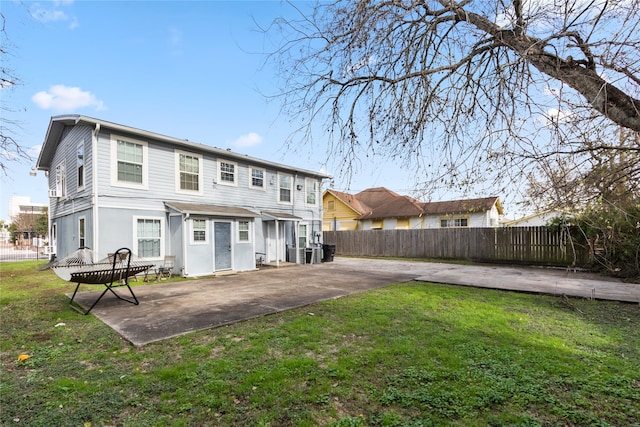 rear view of house with a lawn and a patio