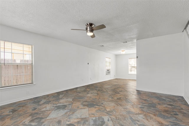 spare room featuring cooling unit, ceiling fan, and a textured ceiling