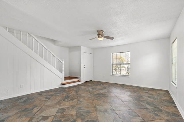 interior space featuring ceiling fan and a textured ceiling