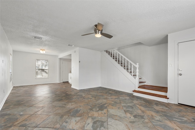 unfurnished room with ceiling fan and a textured ceiling