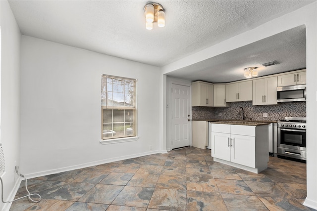 kitchen with a textured ceiling, backsplash, sink, and stainless steel appliances