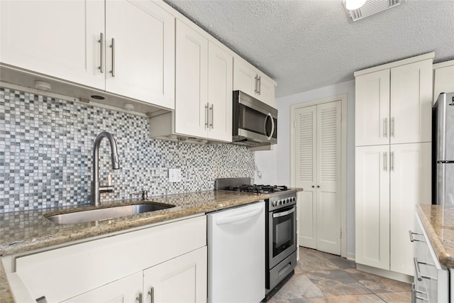 kitchen with white cabinetry, tasteful backsplash, stone countertops, stainless steel appliances, and sink