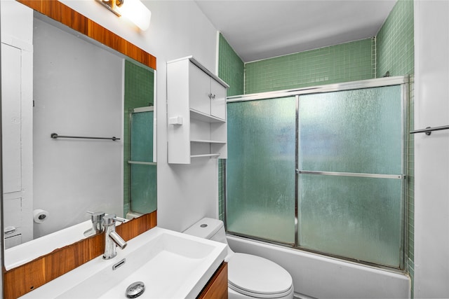 full bathroom with bath / shower combo with glass door, vanity, and toilet