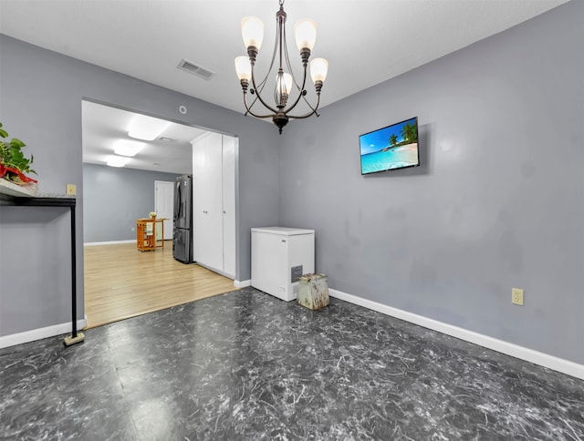 unfurnished dining area featuring an inviting chandelier and hardwood / wood-style floors