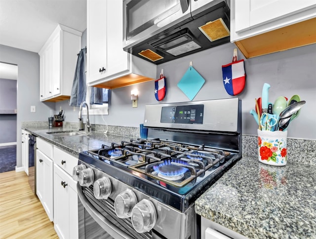 kitchen featuring light hardwood / wood-style flooring, white cabinetry, appliances with stainless steel finishes, and sink