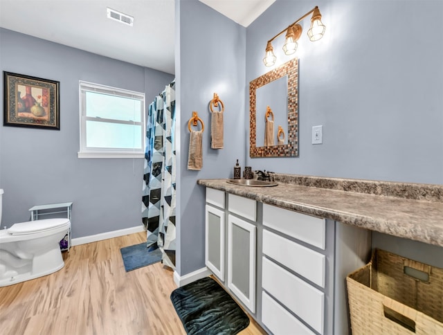 bathroom with curtained shower, vanity, toilet, and hardwood / wood-style flooring