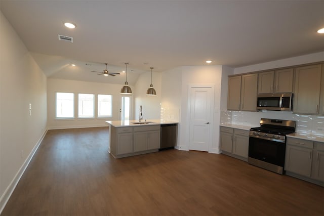 kitchen featuring appliances with stainless steel finishes, sink, gray cabinetry, hanging light fixtures, and kitchen peninsula