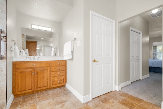 bathroom featuring a textured ceiling and vanity