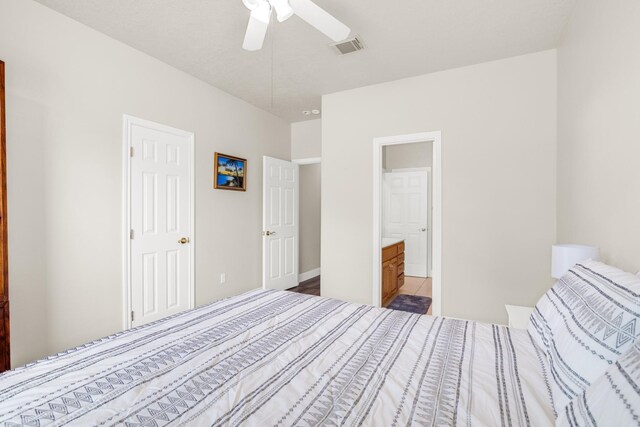 unfurnished bedroom with ceiling fan, ensuite bathroom, and hardwood / wood-style flooring