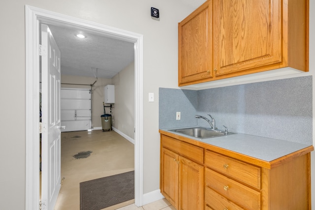 kitchen featuring backsplash, a textured ceiling, water heater, and sink