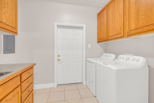 laundry area with cabinets, light tile patterned flooring, and washing machine and dryer