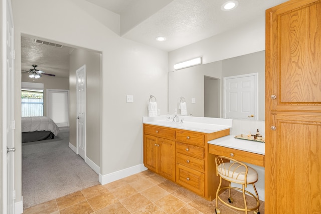 bathroom featuring tile patterned floors, ceiling fan, vanity, and a textured ceiling