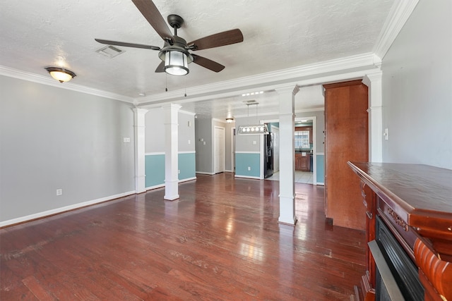 unfurnished living room with ornate columns, crown molding, dark hardwood / wood-style flooring, and ceiling fan